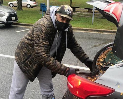 man unloading the trunk of his car