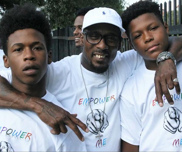 two young african american men posing with their coach